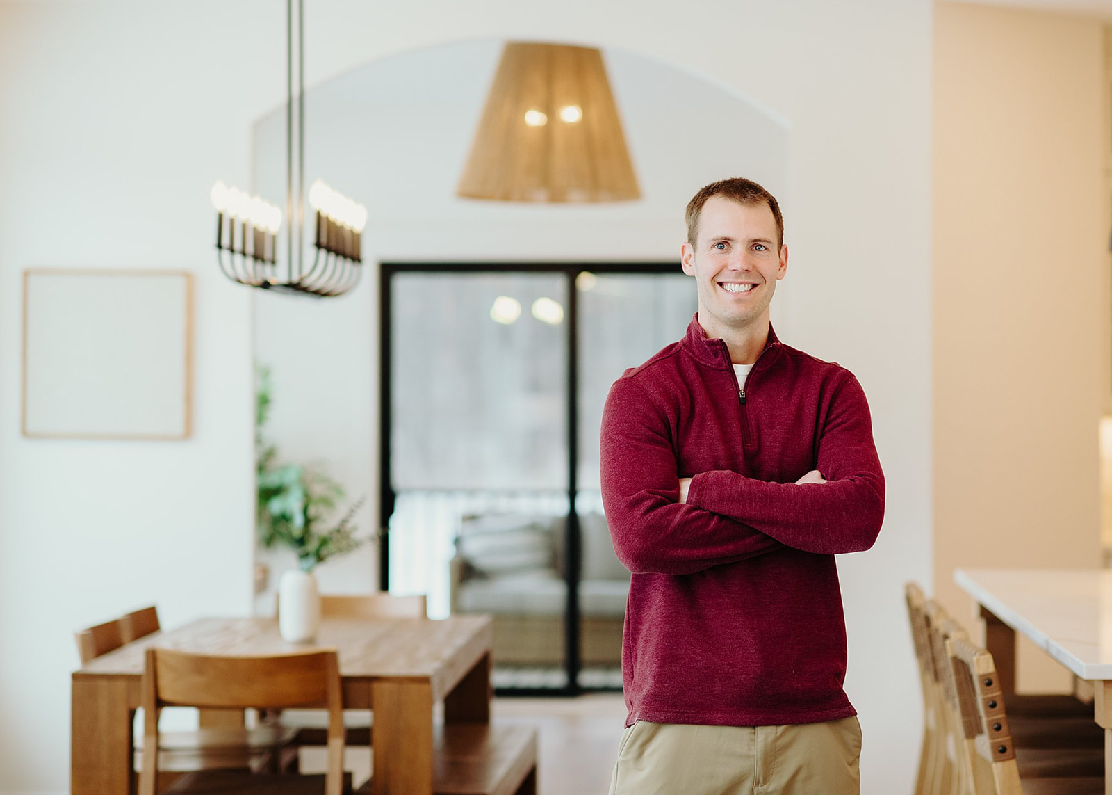 Erik Olson smiling with arms crossed inside a bright, modern home